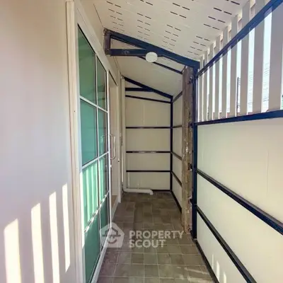 Cozy enclosed balcony with tiled floor and sliding glass door, perfect for relaxation.