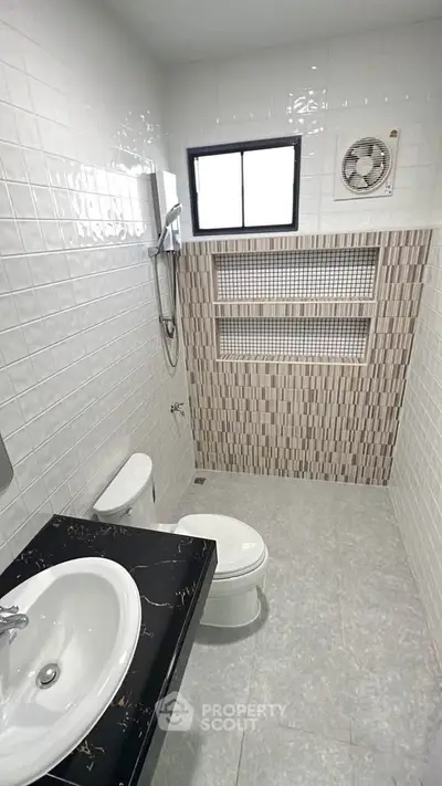 Modern bathroom with sleek design, featuring a stylish sink and tiled walls.