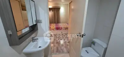 Modern bathroom with sleek fixtures leading to a cozy bedroom with stylish decor.