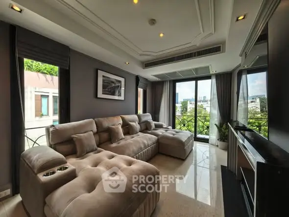 Luxurious living room with plush sectional sofa and large windows offering a stunning city view.