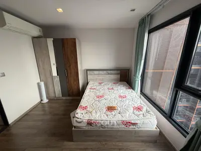 Spacious bedroom with large windows and modern furnishings in a stylish apartment.