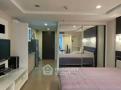 Spacious modern bedroom with mirrored wardrobe and cozy lighting in a stylish apartment.