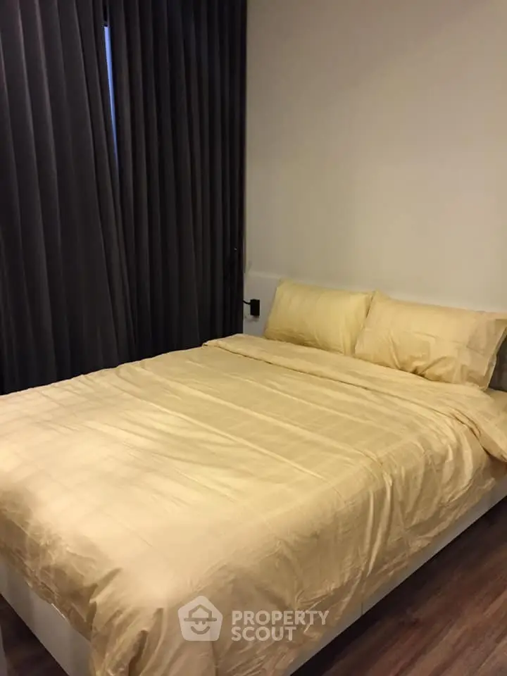 Cozy bedroom with elegant curtains and comfortable bedding in modern apartment.