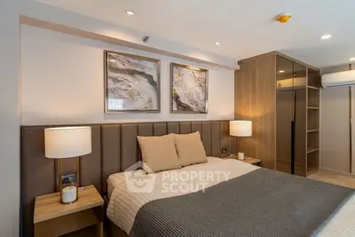 Luxurious bedroom with modern decor and ambient lighting, featuring stylish artwork and cozy bedding.