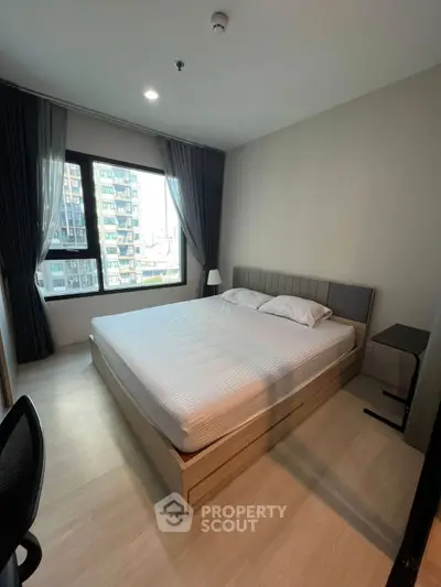 Modern bedroom with large window and stylish decor in urban apartment