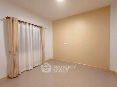 Spacious empty room with beige curtains and tiled floor, perfect for customization.