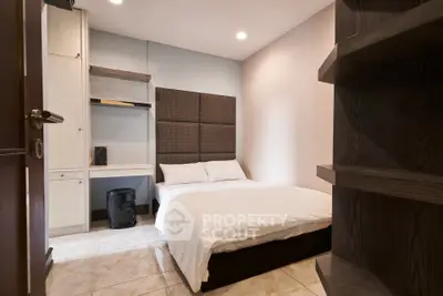 Cozy modern bedroom with stylish shelving and soft lighting, perfect for relaxation.