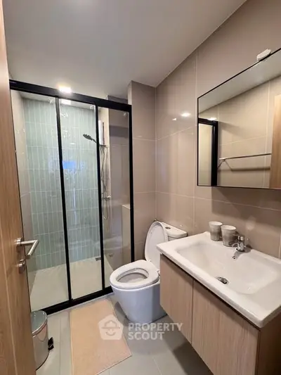 Modern bathroom with sleek shower and elegant fixtures in a contemporary apartment.