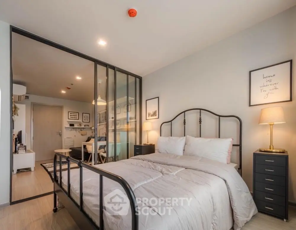 Modern bedroom with glass partition and cozy decor in stylish apartment