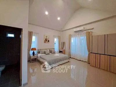 Spacious modern bedroom with high ceiling and elegant decor