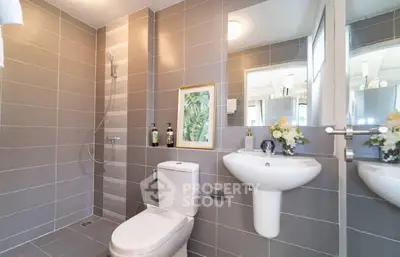 Modern bathroom with sleek gray tiles and elegant fixtures in a contemporary home.