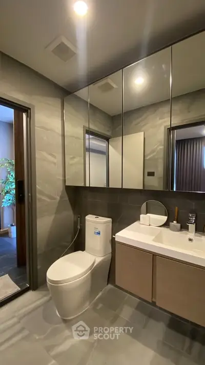 Modern bathroom with sleek fixtures and large mirror cabinets.