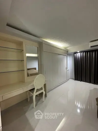 Spacious bedroom with elegant built-in wardrobe and vanity area