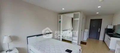 Modern bedroom with mirrored wardrobe and compact kitchen area