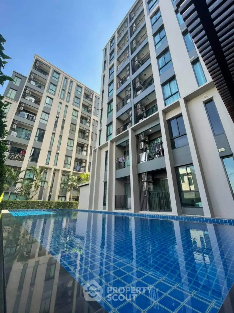 Modern apartment building with a stunning pool view, perfect for luxury living.