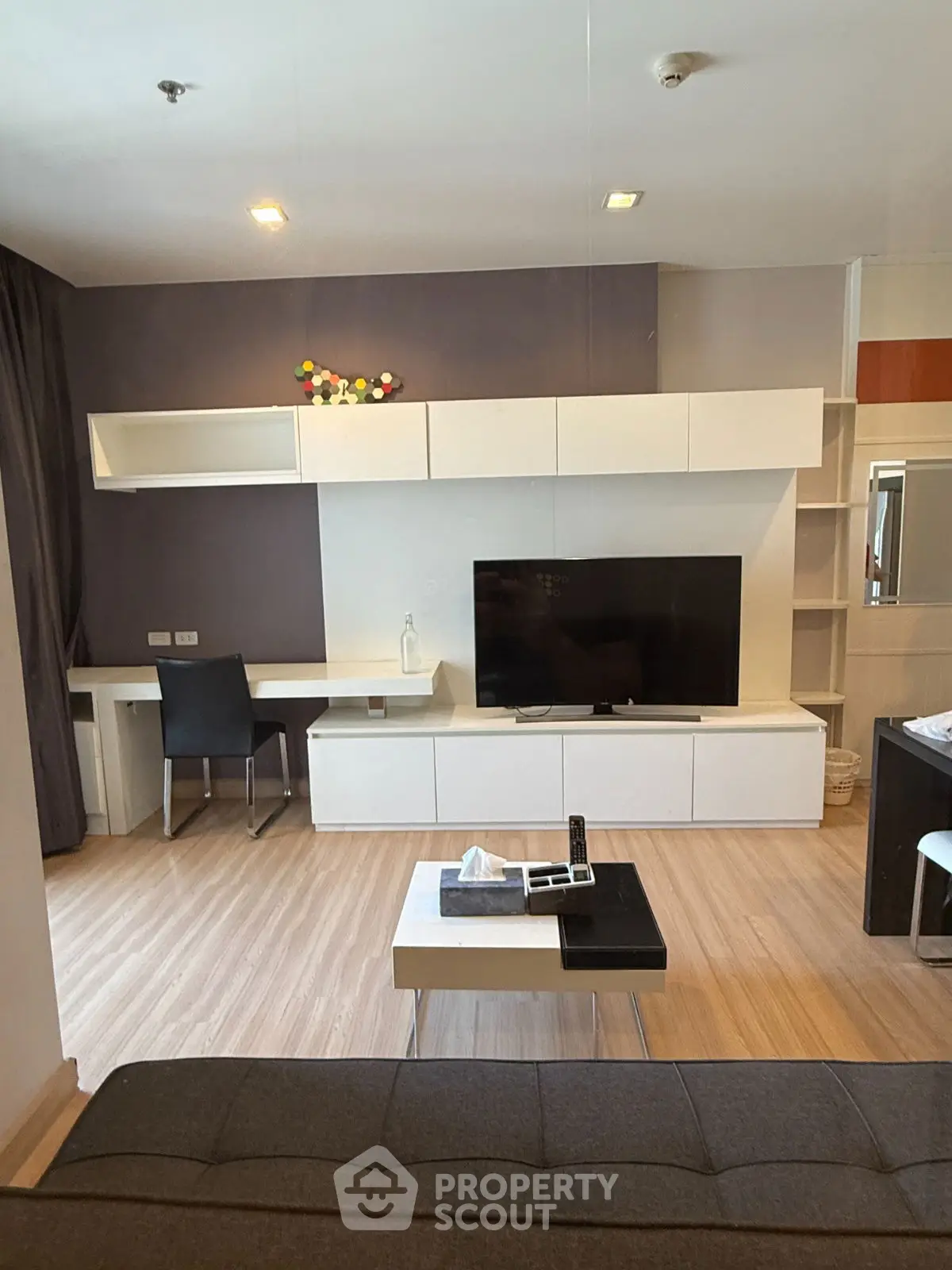 Modern living room with sleek furniture and large TV