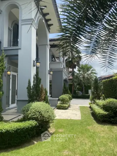 Luxurious villa exterior with lush garden and elegant architectural design