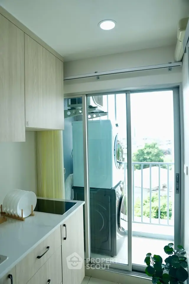 Modern kitchen with balcony view and stacked washer dryer in compact space