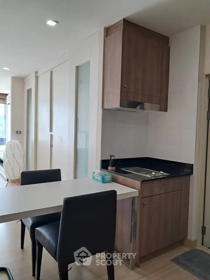 Modern kitchen with sleek cabinetry and dining area in stylish apartment