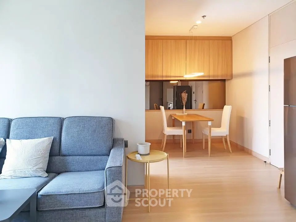 Modern living room with cozy sofa and dining area in open layout apartment.