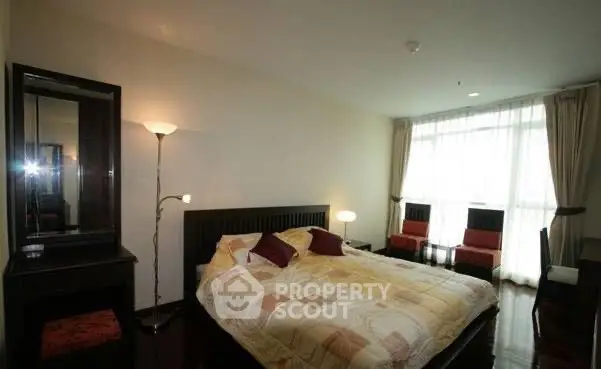 Spacious bedroom with large window and modern decor