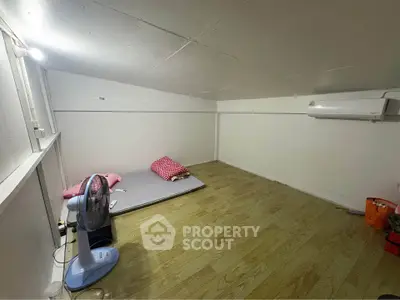 Cozy minimalist room with wooden flooring and air conditioning, perfect for a simple lifestyle.