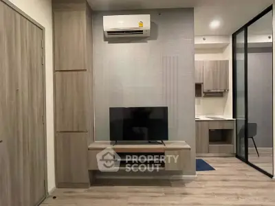 Modern living room with sleek design, featuring a wall-mounted TV and air conditioning unit.