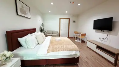 Spacious modern bedroom with stylish decor and wall-mounted TV
