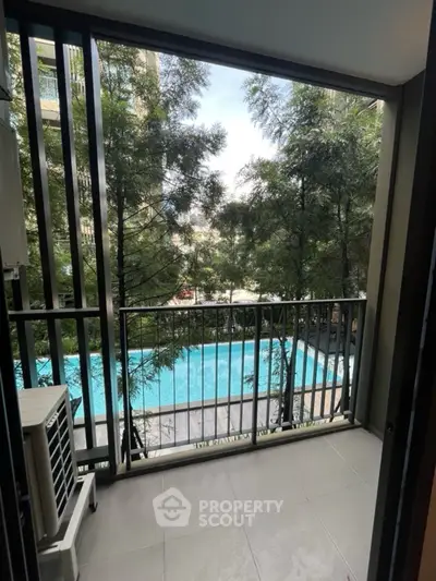 Charming balcony with pool view and lush greenery in modern apartment