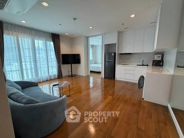 Spacious modern living room with open kitchen and elegant wooden flooring