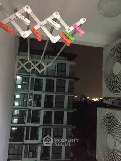 Night view from a balcony with city lights and modern building exterior
