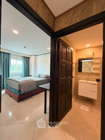 Spacious bedroom with ensuite bathroom in modern apartment