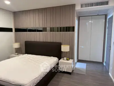 Modern bedroom with stylish padded wall and sleek furniture