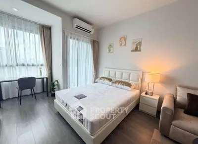 Modern bedroom with stylish decor, large window, and cozy ambiance in a contemporary apartment.
