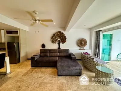 Spacious living room with modern decor and large sofa, opening to a balcony with natural light.