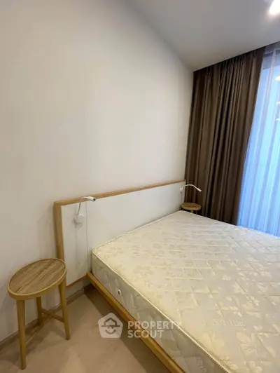 Modern bedroom with minimalist design featuring a comfortable bed and elegant curtains.