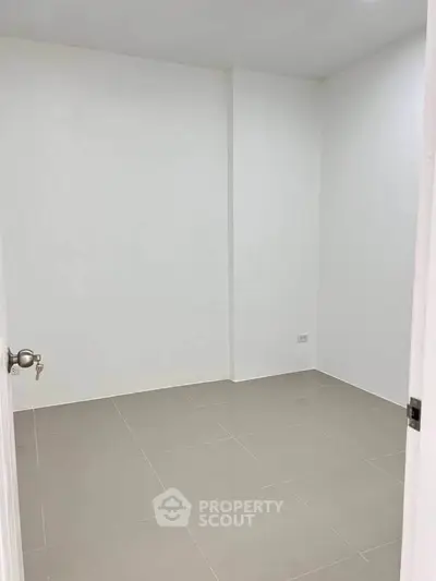 Minimalist empty room with white walls and tiled floor, perfect for customization.