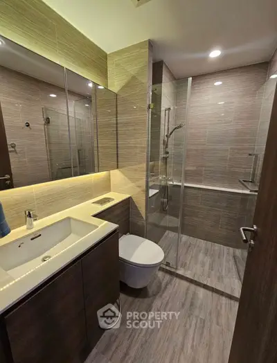 Modern bathroom with sleek design, glass shower, and elegant lighting