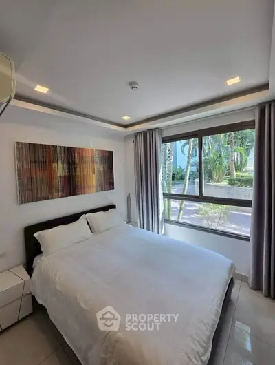 Modern bedroom with large window and stylish decor in a serene setting.