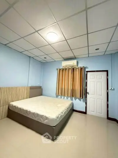 Spacious bedroom with modern design, featuring a comfortable bed and air conditioning, perfect for relaxation.