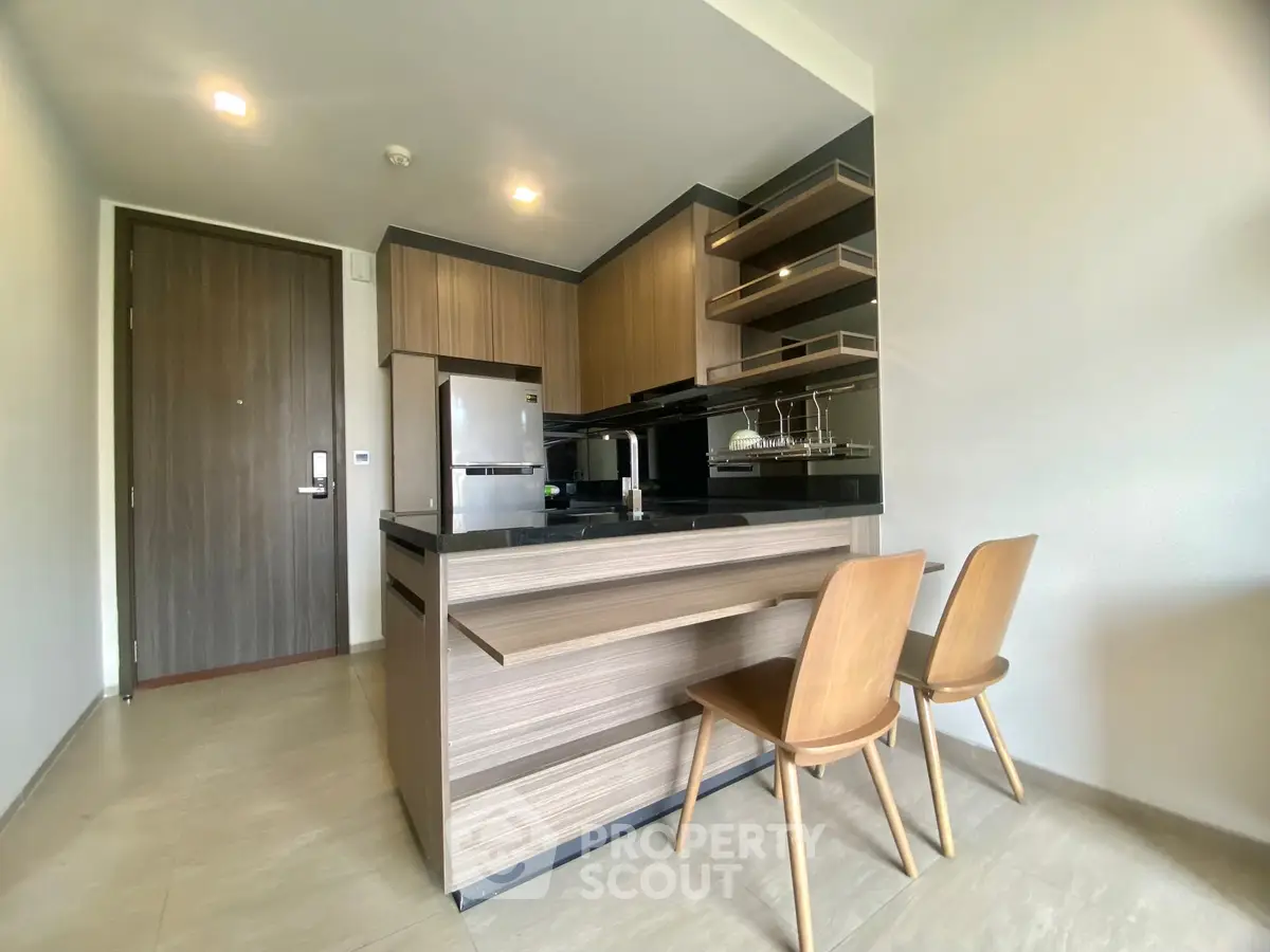 Modern kitchen with sleek wooden cabinetry and stylish bar seating