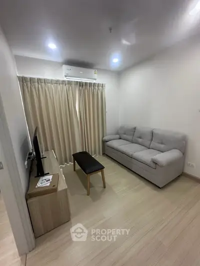 Cozy living room with modern sofa and TV, perfect for relaxation.