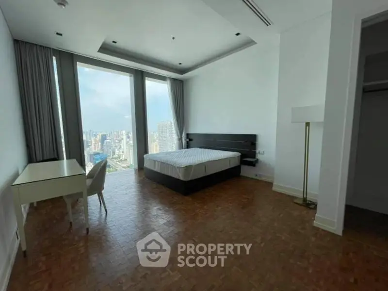 Spacious bedroom with stunning city view and elegant parquet flooring.