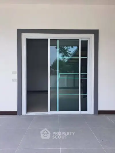 Modern sliding glass door leading to a spacious patio area, perfect for indoor-outdoor living.