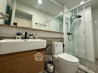 Modern bathroom with sleek shower and stylish vanity in contemporary apartment.