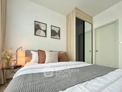 Modern bedroom with stylish decor and cozy ambiance, featuring a comfortable bed and elegant wall art.