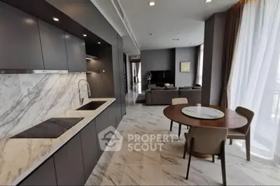 Luxurious open-plan kitchen and living area with modern marble finishes and elegant furniture.