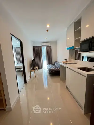 Modern open-plan living room with sleek kitchen and cozy seating area, perfect for urban living.