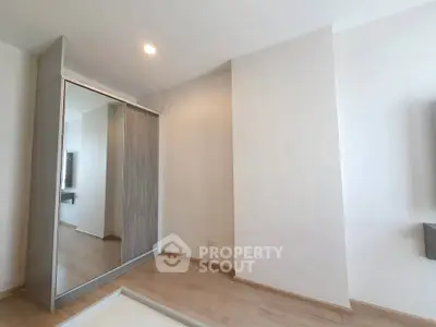 Spacious bedroom with modern wardrobe and wooden flooring