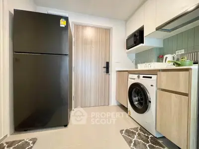 Modern kitchen with sleek appliances and stylish cabinetry in a contemporary apartment.